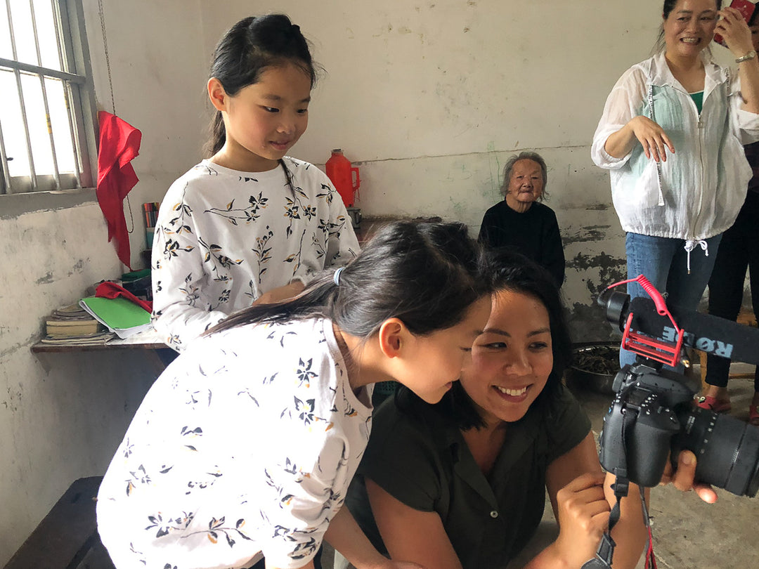 Twins Ling and Ching, 11, get a sneak peek of their photos from KAILU’s founder, EMMY-award winning journalist and former magazine editor LiLi Tan.