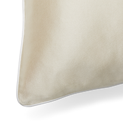 A close up of the piping detail of a KAILU silk pillowcase in champagne with white piping, made with the highest-quality, OEKO-TEX-certified mulberry silk in 25 momme silk weight