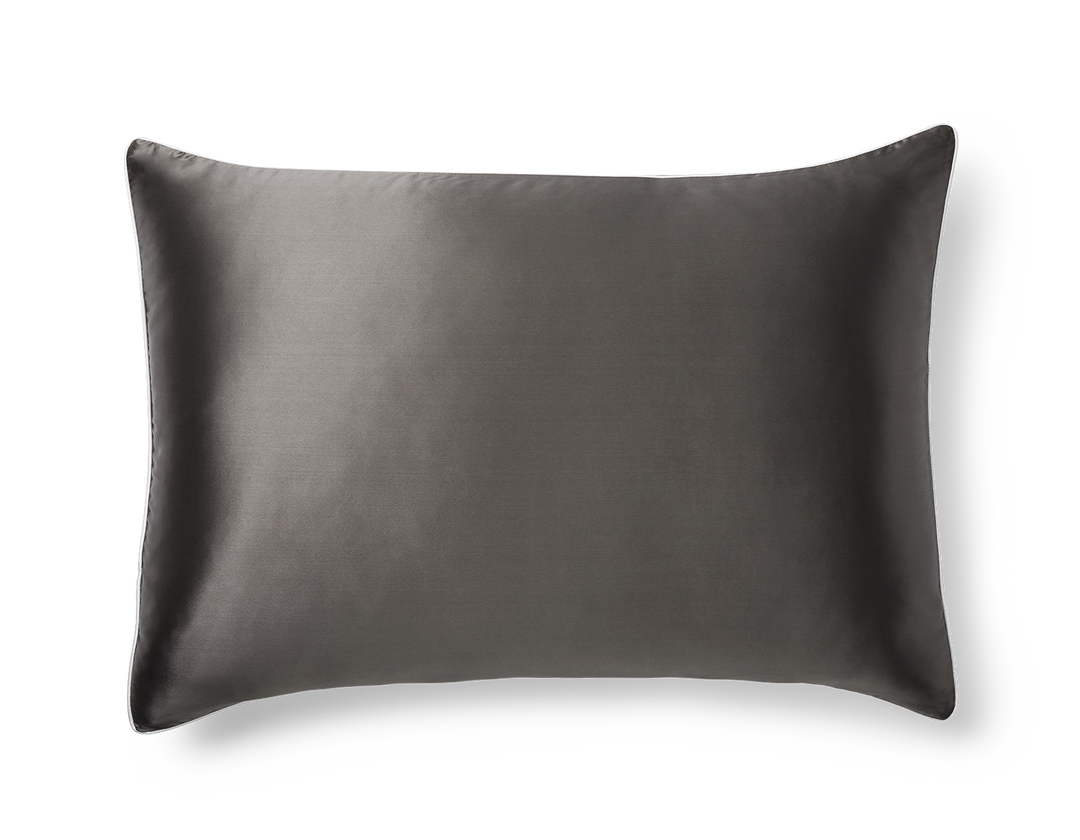 A KAILU silk pillowcase in charcoal with white piping, made with the highest-quality, OEKO-TEX-certified mulberry silk in 22 momme silk weight